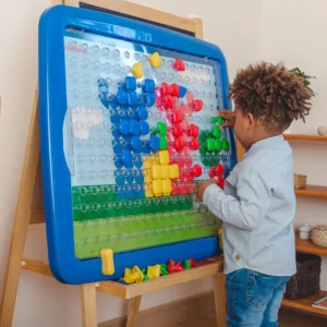 A boy playing with a Superpegs giant board