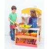 boy and girl playing with a wooden stall with containers