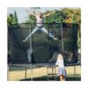 woman jumping in a big black trampoline