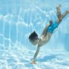 boy wearing swimming goggles dives in a pool