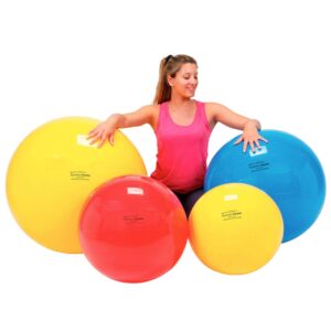 woman in the middle of four physiotherapy balls of different sizes
