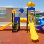 outdoor playground with three slides and a tunel