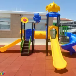outdoor playground with three slides and a tunel