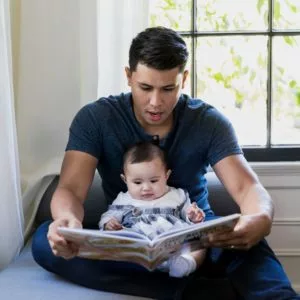 young father reading a book with his baby