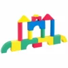 Colorful foam building blocks arranged in an arch and tower structure, featuring various shapes like arches, cylinders, and rectangles in red, yellow, blue, and green.