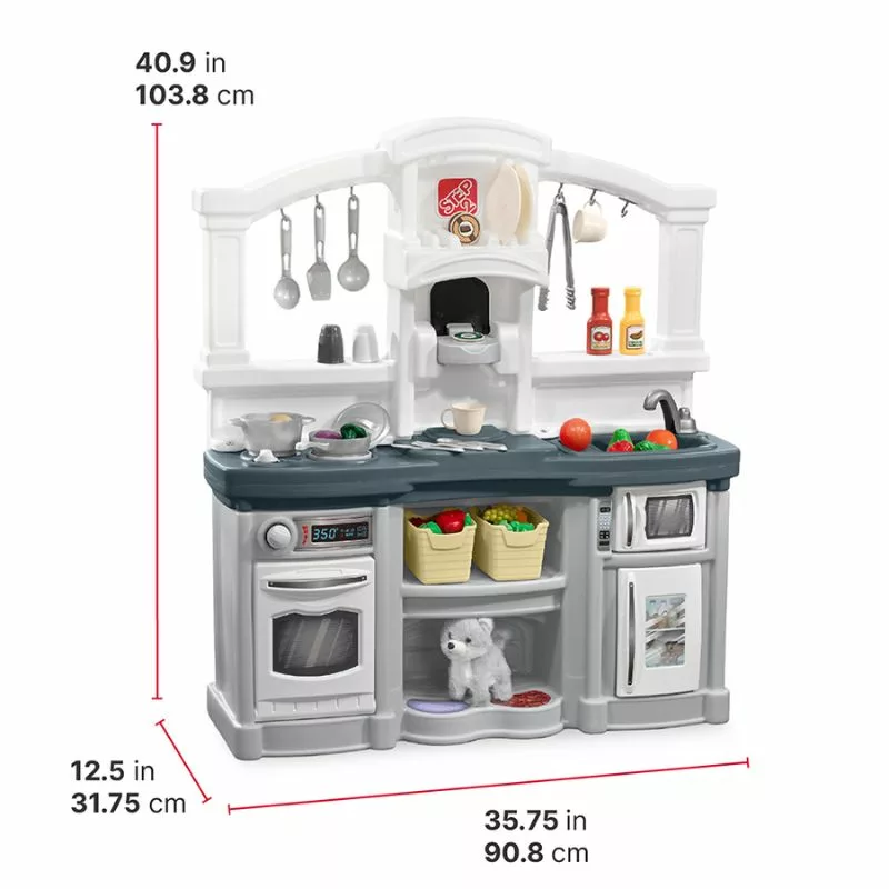 A Step2 toy kitchen playset with gray and white components. The playset includes a sink, a stovetop, an oven, and a microwave. It is stocked with various toy accessories like utensils, pots, and food. A small white toy dog is visible in a cubby. The dimensions of the playset are labeled on the image: 40.9 inches (103.8 cm) tall, 35.75 inches (90.8 cm) wide, and 12.5 inches (31.75 cm) deep.
