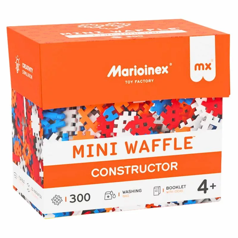 A bright orange and white box of "Marioinex Mini Waffle Constructor 300" building blocks, showing multicolored pieces (red, blue, white, orange) spilling out of the top. The box also indicates features like a washing bag, booklet with ideas, and a 4+ age rating.