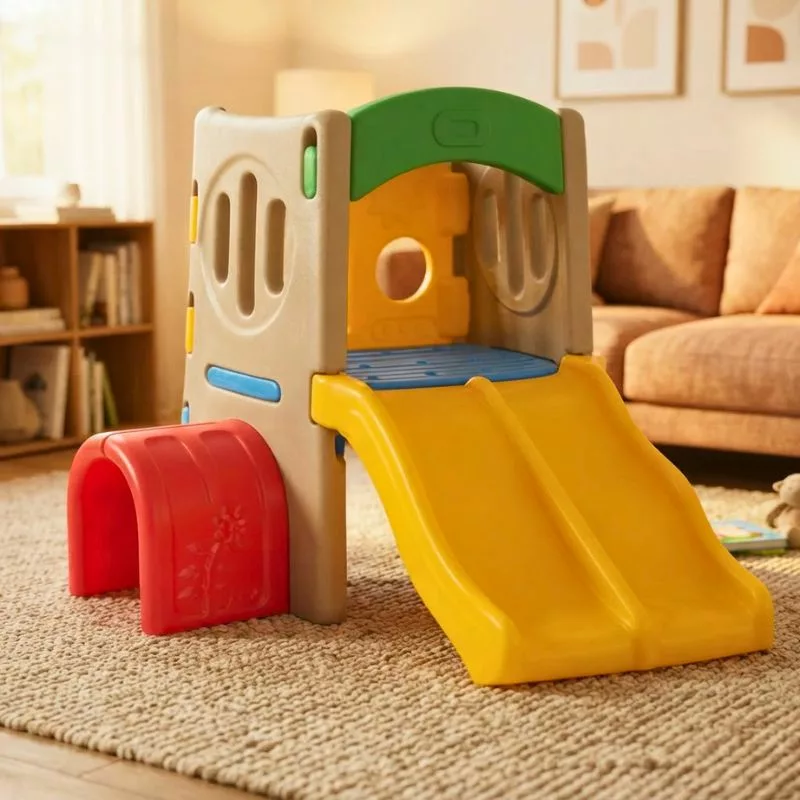 Colorful plastic children's playground with a yellow double slide, red tunnel, climbing panels, and enclosed play area.