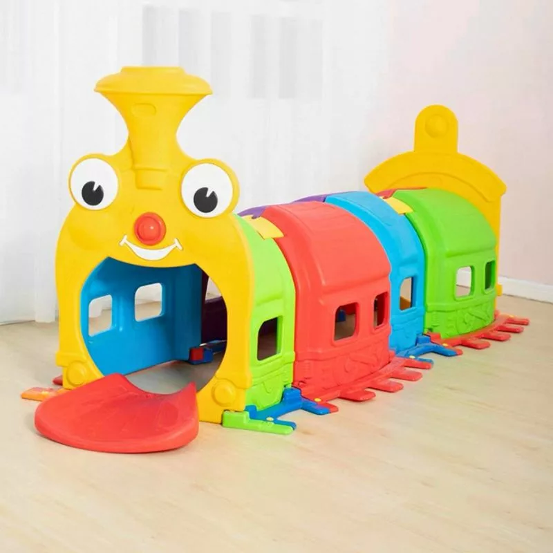 Colorful plastic train-themed playground with a yellow locomotive, connected red, blue, and green play cars, and a front entrance.